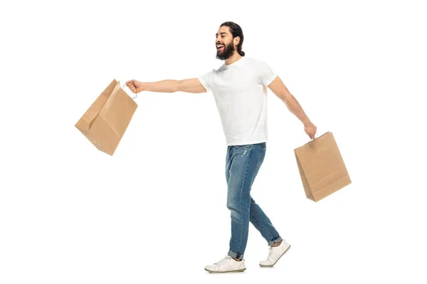 Hombre Latino Feliz Sosteniendo Bolsas Compras Mientras Camina Aislado Blanco — Foto de Stock