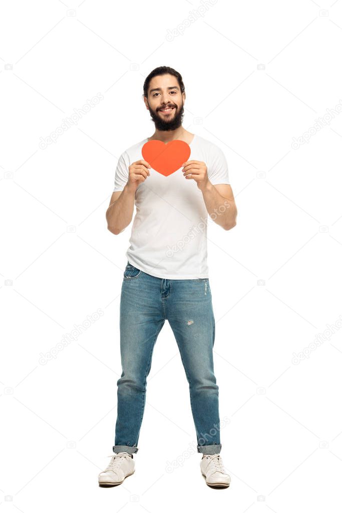 bearded latin man holding red heart-shape carton and smiling isolated on white 