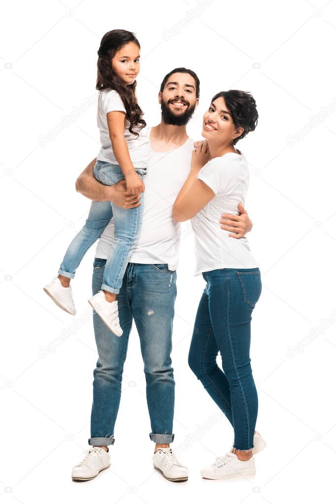 happy latin man holding in arms cute daughter while standing with wife isolated on white 