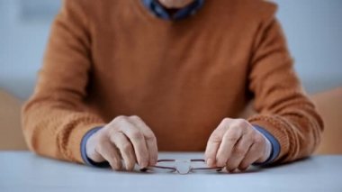 Üst düzey adam gözlük alarak ve evde gülümsüyor odak çekme 