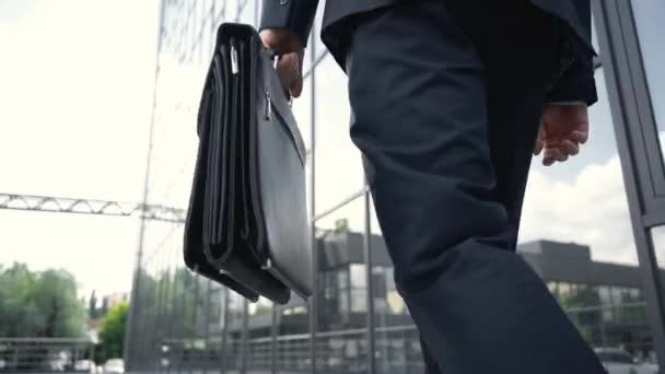 ブリーフケースを持ち 建物の近くを歩くフォーマルな服を着たビジネスマンのトリミングされたビュー — ストック動画