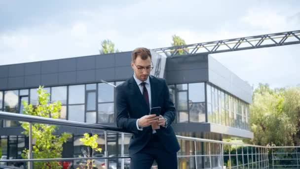 Geschäftsmann Offizieller Kleidung Nutzt Smartphone Tagsüber Der Nähe Von Gebäuden — Stockvideo