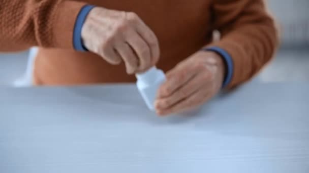 Visão Cortada Homem Sênior Tomando Garrafa Colocando Pílulas Mão Xícara — Vídeo de Stock