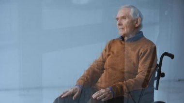 Engelli kıdemli adamın seçici odak tekerlekli sandalye ve dokunmadan gözleri pencere yakın dökülen yağmur ile oturan 