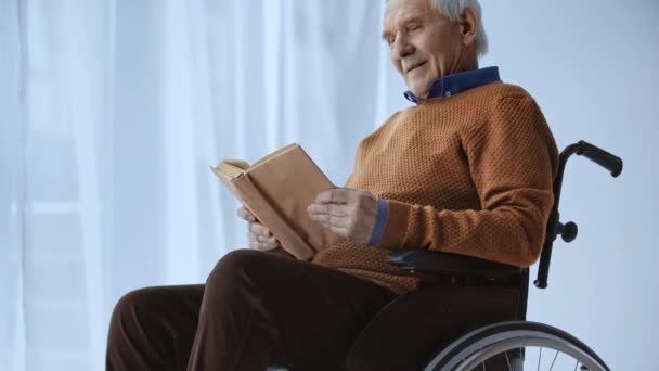 Homem Aposentado Feliz Sentado Cadeira Rodas Livro Leitura Casa — Vídeo de Stock