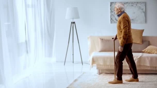 Starszy Mężczyzna Szarymi Włosami Trzymając Chodzenie Kij Podczas Chodzenia Salonie — Wideo stockowe