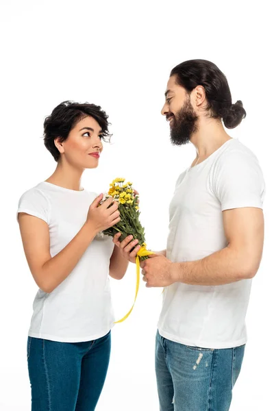 Веселий латинський чоловік дарує квіти привабливій жінці ізольовані на білому — стокове фото