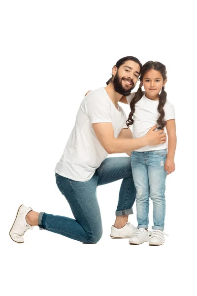 Feliz padre latino sonriendo mientras abraza linda hija aislada en blanco - foto de stock