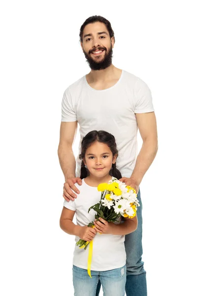Happy latin father standing with cute daughter holding flowers isolated on white — Stock Photo