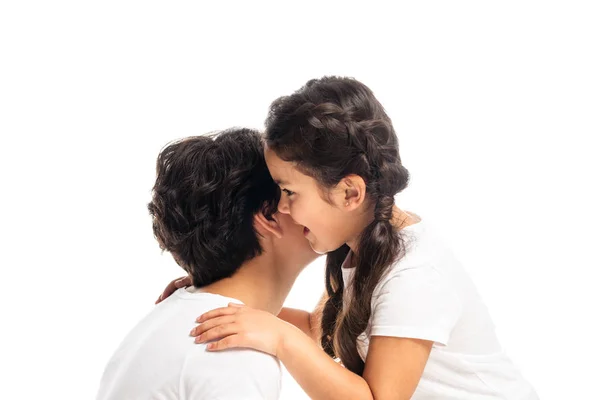 Cute kid whispering while talking near brunette mother isolated on white — Stock Photo