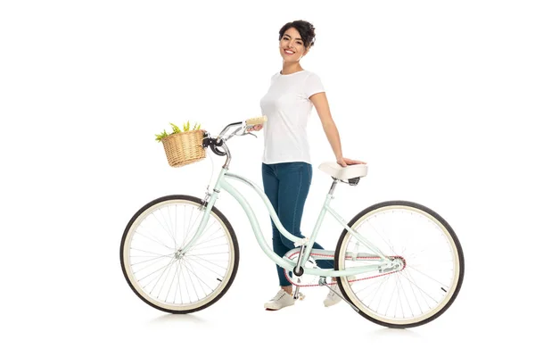 Cheerful latin woman standing with bicycle isolated on white — Stock Photo