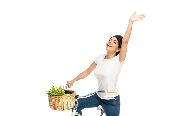 Happy latin woman with outstretched hand riding bicycle isolated on white — Stock Photo