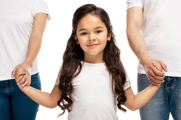 Abgeschnittene Ansicht von Eltern, die Hände mit niedlichen lateinischen Tochter halten, während sie isoliert auf weiß stehen — Stockfoto