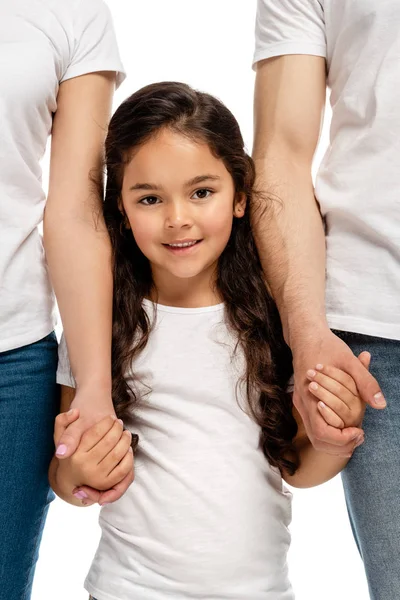 Visão cortada dos pais de mãos dadas com a filha latina alegre, enquanto em pé isolado no branco — Fotografia de Stock