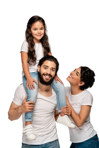 Happy latin father carrying on shoulders cute daughter near happy wife isolated on white — Stock Photo