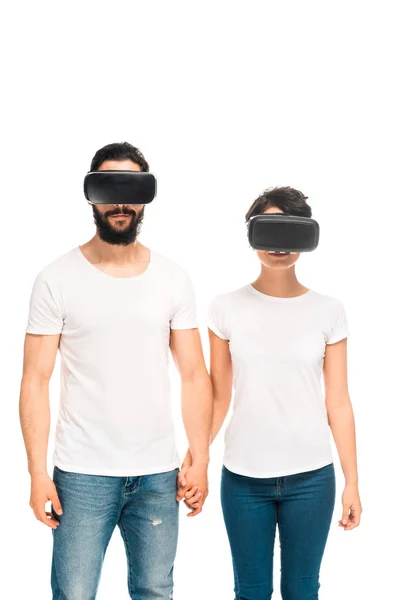 Latin man and woman wearing virtual reality headsets and holding hands while standing isolated on white — Stock Photo