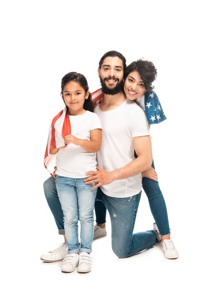 Fröhliche lateinische Familie lächelt, während sie die amerikanische Flagge isoliert auf weiß hält — Stockfoto