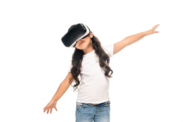 Entzückendes lateinisches Kind, das mit ausgestreckten Händen steht, während es Virtual-Reality-Headset isoliert auf weiß trägt — Stockfoto
