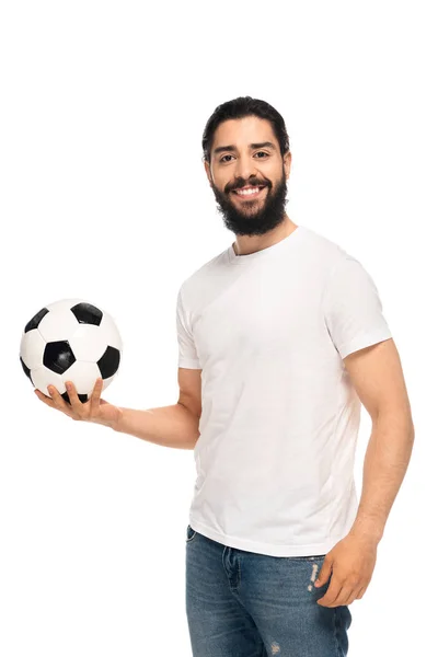Feliz latino sosteniendo pelota de fútbol y sonriendo aislado en blanco - foto de stock