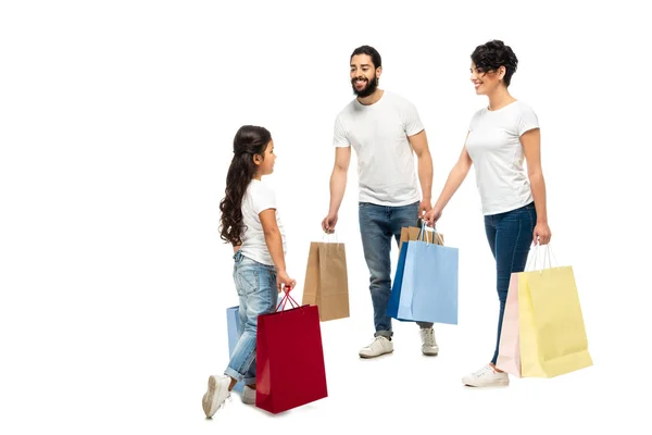 Pais latinos felizes segurando sacos de compras enquanto olha para a filha isolada no branco — Fotografia de Stock