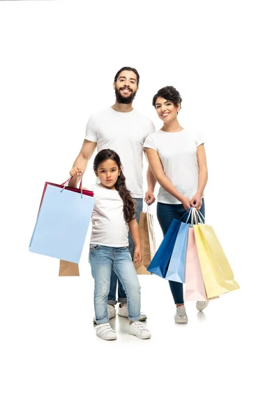 Щасливі латинські батьки тримають сумки в той час як стоячи з милою дочка ізольований на білому — стокове фото