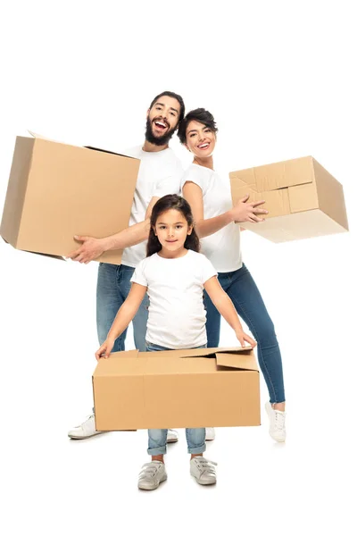 Feliz latina padres sosteniendo cajas y sonriendo cerca lindo hija aislado en blanco - foto de stock