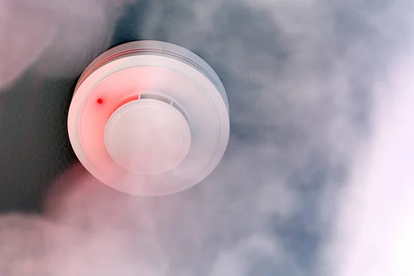 Dire alarm smoke detector with red LED indicator on ceiling — Stock Photo, Image