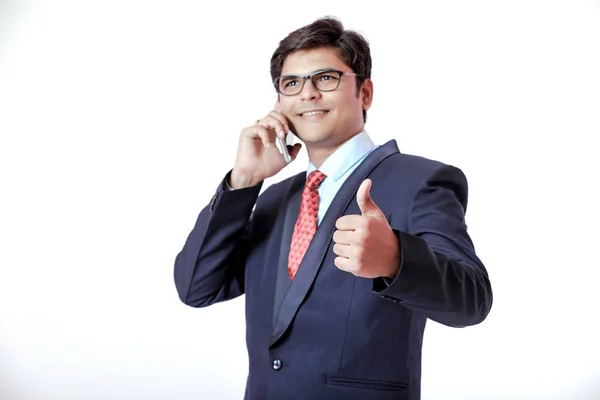 孤立した背景に携帯電話で話している若いインド人ビジネスマン — ストック写真