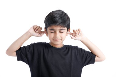 Indian little boy over isolated white background , covering ears with hands.