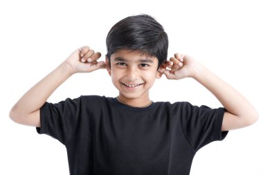 Indian little boy over isolated white background , covering ears with hands.