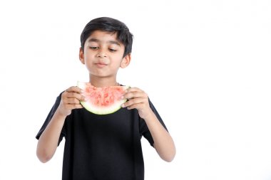 little Indian boy eating watermelon with multiple expressions  