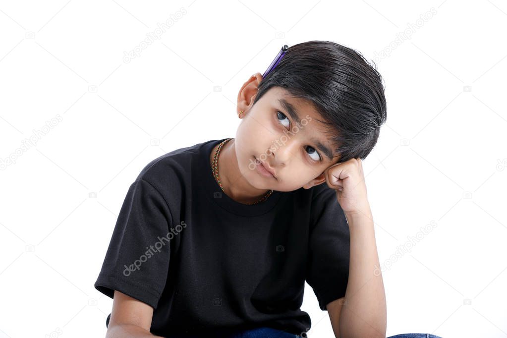 Cute Indian boy thinking idea and looking at up, isolated on white background 