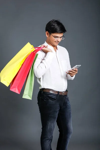 Indian Man Shopping Bags Showing Mobile Screen — стоковое фото