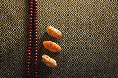 Date fruits with an Islamic prayer beads on an artistic background. Beautiful background for Ramzan or Ramadan. 