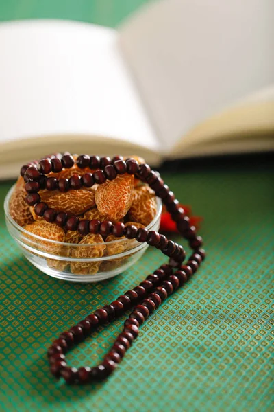 Date fruits with an Islamic prayer beads on an artistic background. Beautiful background for Ramzan or Ramadan.