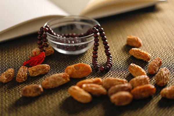 Date fruits with an Islamic prayer beads on an artistic background. Beautiful background for Ramzan or Ramadan.