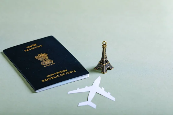 travel concept , Indian passport with paper airplane ,Eiffel tower miniature