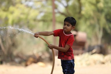 indian child playing with water tube