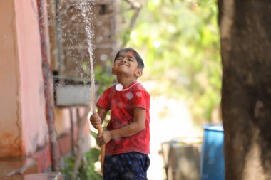 indian child playing with water tube