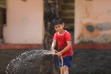 indian child playing with water tube