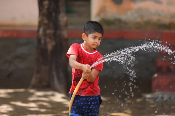 indian child playing with water tube