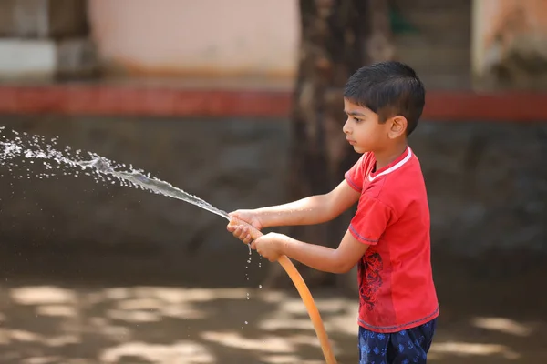 Indian Child Playing Water Tube — Stock Fotó