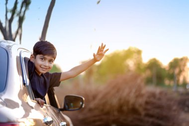 Cute Indian Child waving from car window