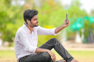 Young indian Collage student using mobile 