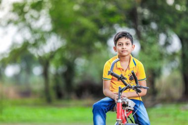 Indian child on bicycle, playing in outdoor