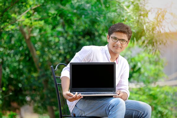 ノート パソコンの画面を示す若いインド人 — ストック写真