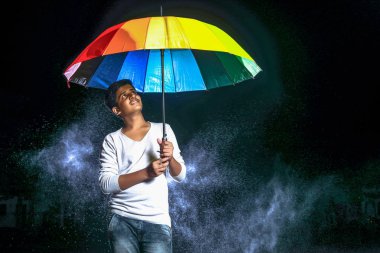 Indian boy holding umbrella in hand