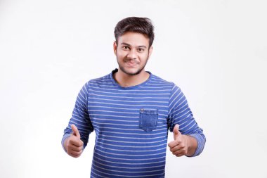 Handsome young Indian man showing thumps up isolated over white background