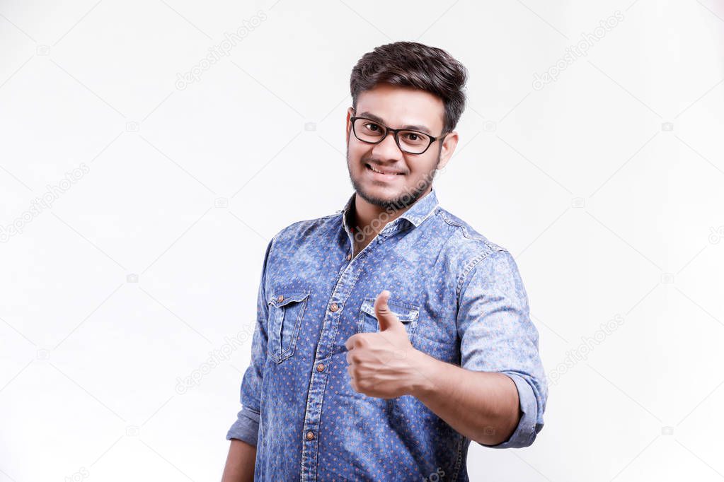Handsome young Indian man showing thumps up isolated over white background