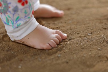 feet of a baby in the sand